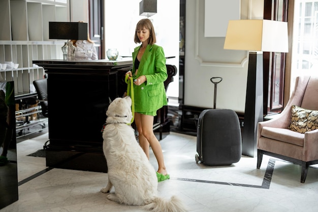 Femme d'affaires avec son chien à la réception de l'hôtel