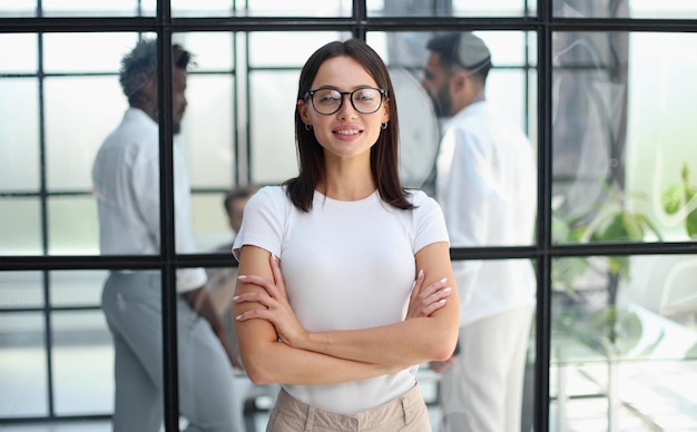 Femme d&#39;affaires avec son personnel en arrière-plan au bureau