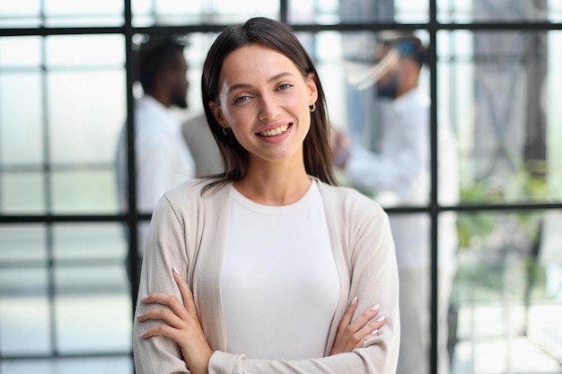 Femme d&#39;affaires avec son personnel en arrière-plan au bureau