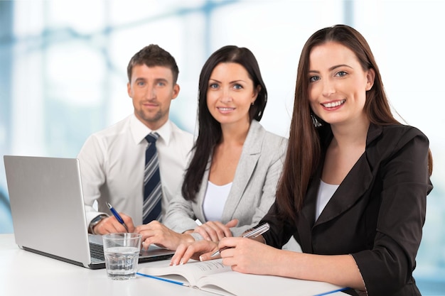 Femme d'affaires avec son personnel, groupe de personnes en arrière-plan au bureau lumineux moderne à l'intérieur