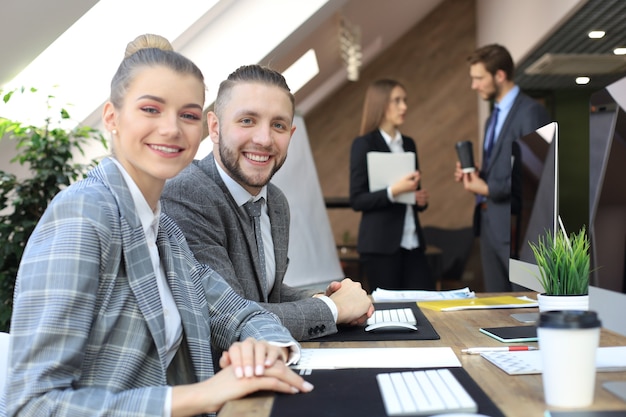 Femme d'affaires avec son personnel, groupe de personnes en arrière-plan dans un bureau moderne et lumineux à l'intérieur.