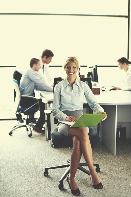 femme d'affaires avec son personnel, groupe de personnes en arrière-plan dans un bureau moderne et lumineux à l'intérieur