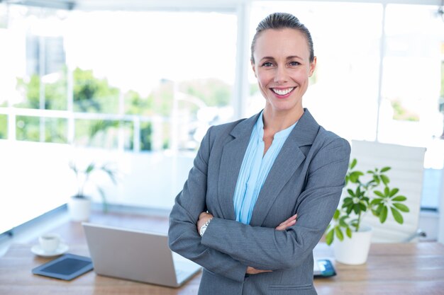 Femme d&#39;affaires souriant avec les bras croisés