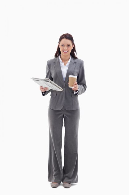 Femme d&#39;affaires souriant avec un café et un journal