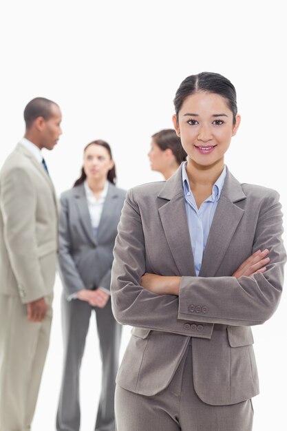 Femme d&#39;affaires en souriant et en croisant les bras avec des collègues