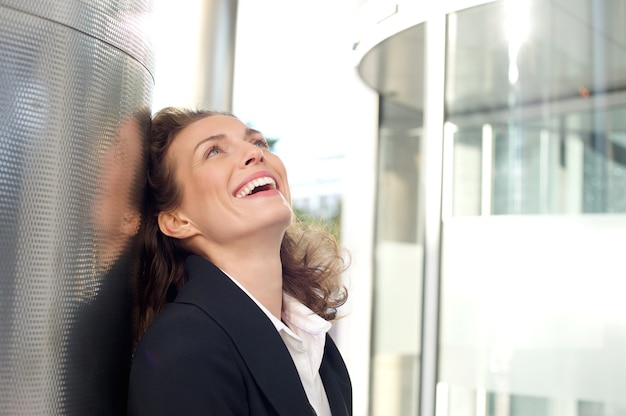 Femme d&#39;affaires souriant à l&#39;extérieur de l&#39;immeuble de bureaux