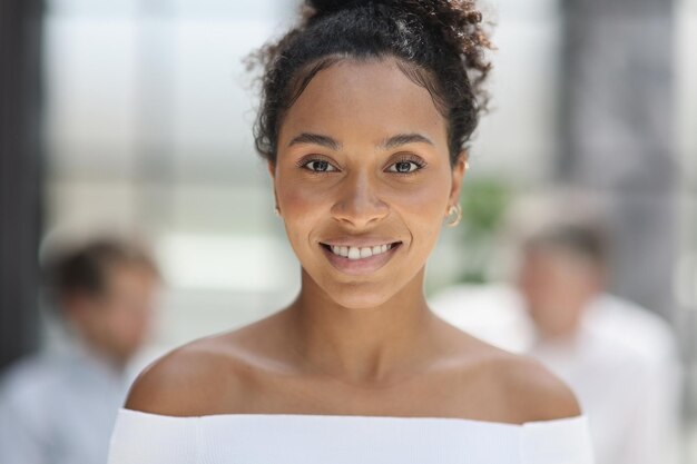 Une femme d'affaires souriant à l'intérieur d'un immeuble de bureaux