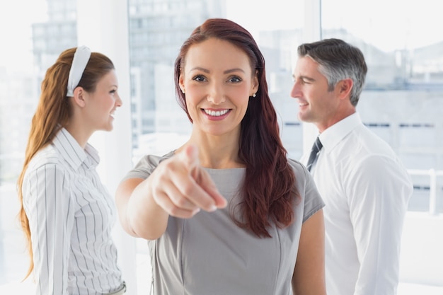 Femme d&#39;affaires souriant pointant à la caméra