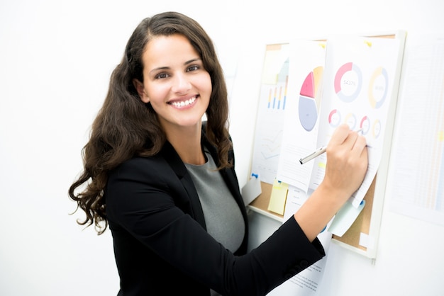 Femme d&#39;affaires souriant présentant des données sur le tableau