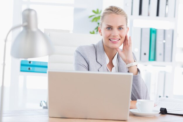 Femme d&#39;affaires souriant avec son ordinateur