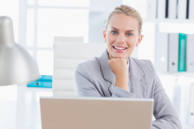 Femme d&#39;affaires souriant avec son ordinateur