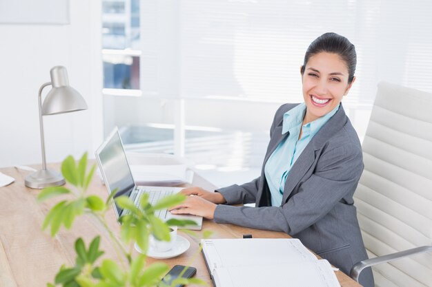 Femme d&#39;affaires souriant avec son ordinateur