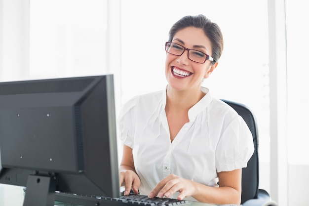 Femme d&#39;affaires souriant travaillant à son bureau