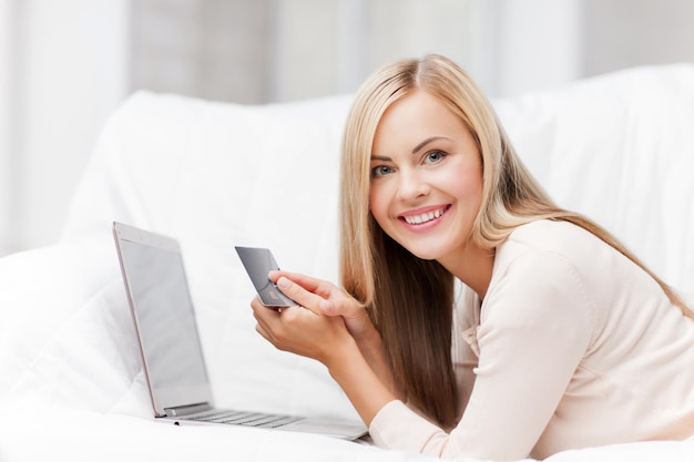 femme d'affaires souriante avec ordinateur portable et carte de crédit