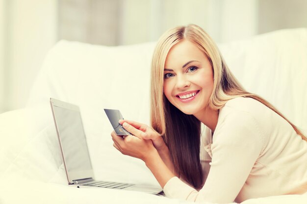 femme d'affaires souriante avec ordinateur portable et carte de crédit