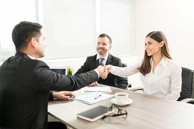 Femme d'affaires souriante serrant la main d'un employé au bureau au bureau