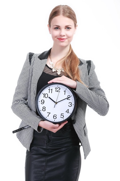 Femme d'affaires souriante tenant dans les mains l'horloge, isolée sur blanc