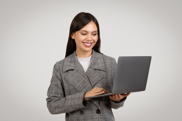 Femme d'affaires souriante utilisant la technologie d'un ordinateur portable au travail