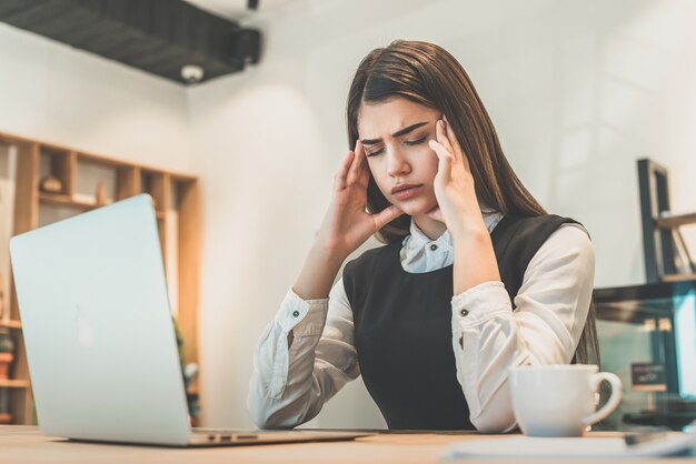 La femme d'affaires stressée assise à la table