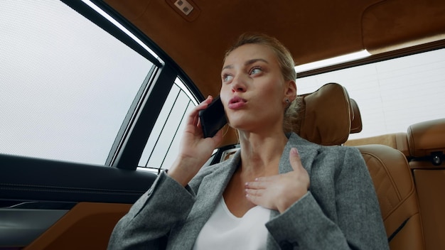 Femme d'affaires stressée parlant au téléphone dans la voiture Femme se disputant au téléphone dans la voiture