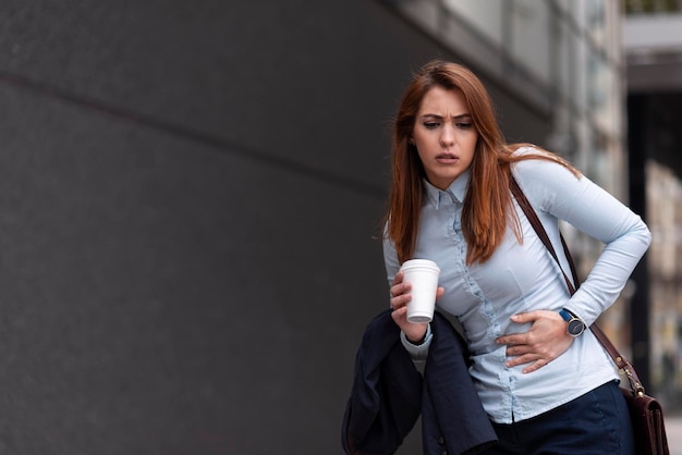 Femme d'affaires stressée souffrant de douleurs à l'estomac