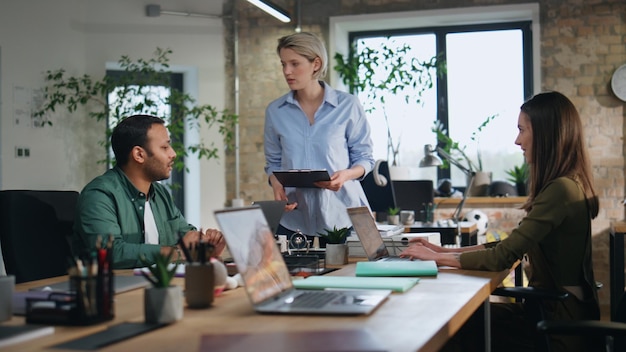 Femme d'affaires supervisant des employés de bureau sur le lieu de travail