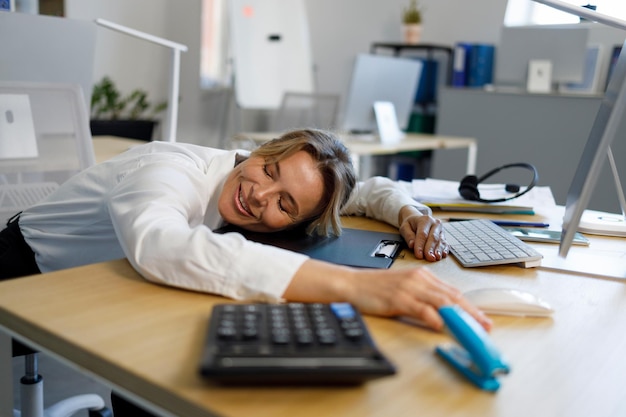 Femme d'affaires surmenée appréciant le repos sur le lieu de travail