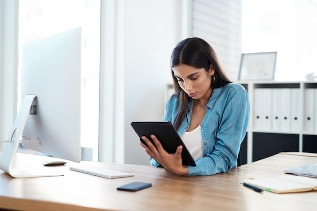 Femme d'affaires et tablette au bureau pour l'agenda de courrier électronique et la mise à jour des informations sur les clients Technologie comptable et occupée avec une application en ligne pour la facturation ou un logiciel numérique pour la recherche et la rétroaction