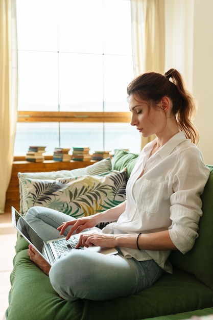 Femme d'affaires tapant un e-mail sur un ordinateur portable au bureau à domicile