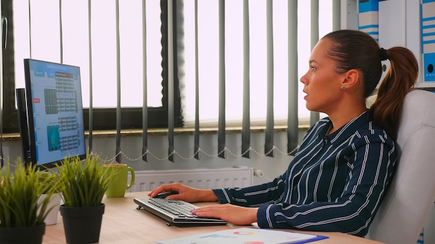 Femme d'affaires tapant sur ordinateur dans une salle de bureau moderne. Entrepreneur hispanique travaillant dans un espace de travail professionnel, dans une entreprise personnelle écrivant sur un clavier d'ordinateur en regardant le bureau