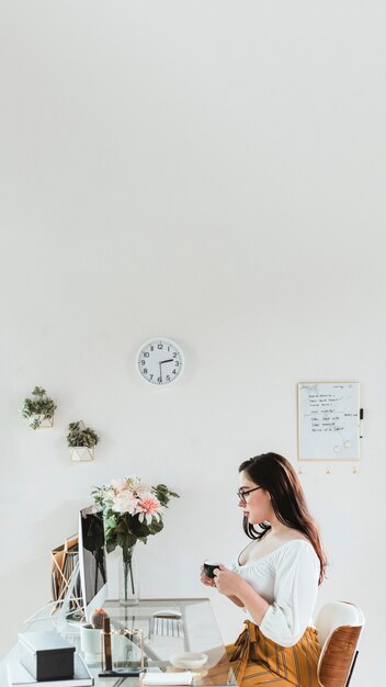 Femme D'affaires Avec Une Tasse De Café Au Bureau