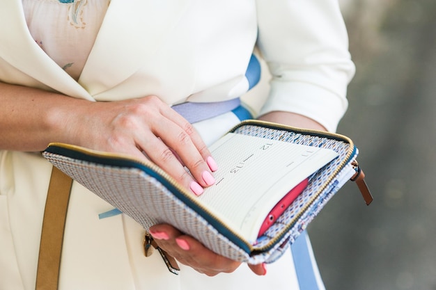 femme d'affaires tenant un journal intime et un bloc-notes dans ses mains