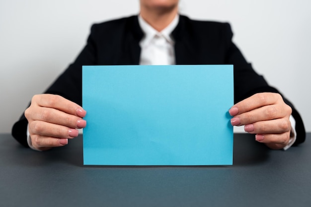 Femme d'affaires tenant une note avec un message important sur le bureau