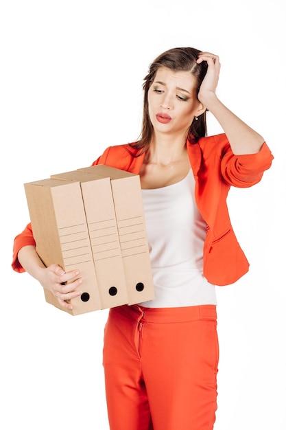 Femme d'affaires tenant une pile de boîtes sur un fond blanc.