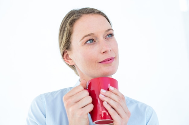 Femme d&#39;affaires tenant sa tasse et la pensée