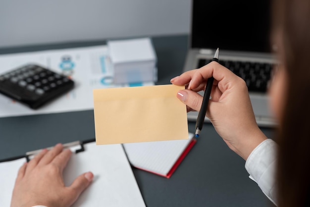 Femme d'affaires tenant un stylo et une note avec un message important d'une main