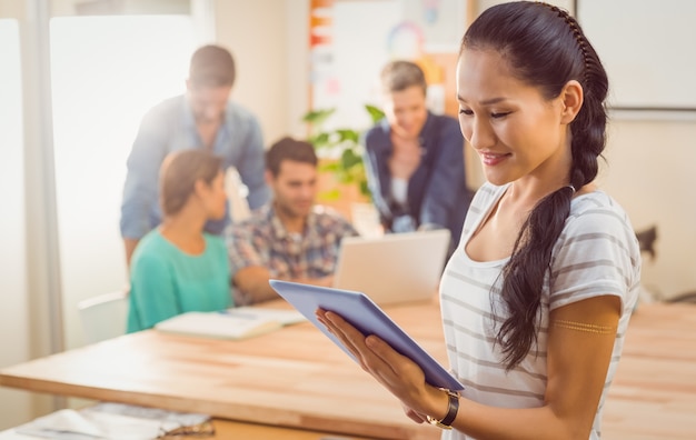 Femme d&#39;affaires tenant une tablette au bureau