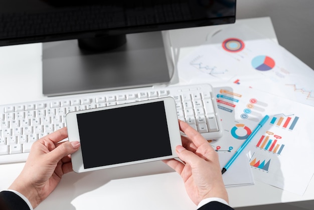 Femme d'affaires tenant une tablette avec de nouvelles idées sur le bureau avec ordinateur et clavier