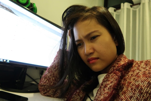 Photo une femme d'affaires tendue qui utilise l'ordinateur à son bureau.