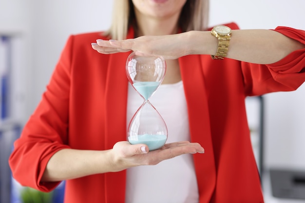 La femme d'affaires tient un sablier dans ses mains