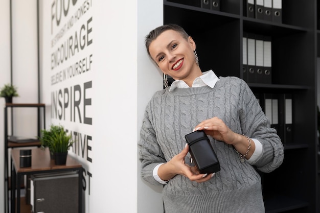 Femme d'affaires avec un timbre dans ses mains au bureau