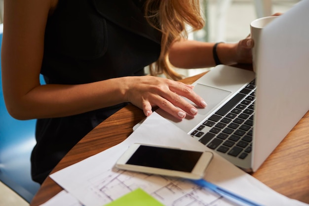 Femme d'affaires travaillant au bureau à l'aide d'un ordinateur portable à mi-section