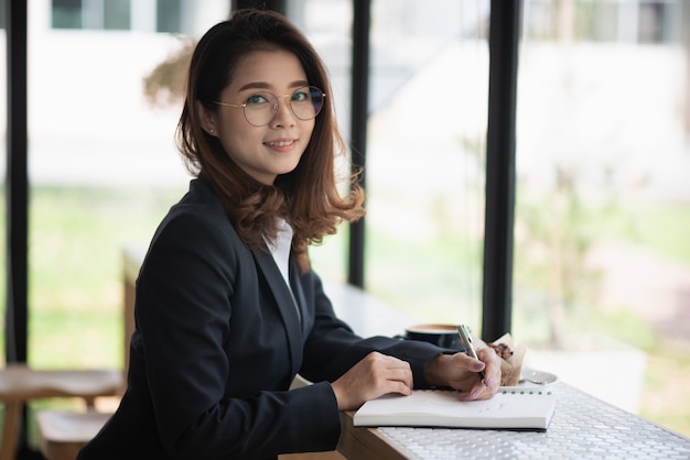 Femme d'affaires travaillant avec carnet de notes sur la table, concept d'entreprise