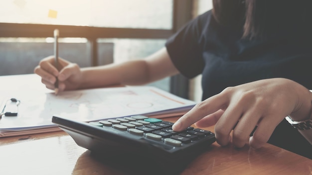 Femme d'affaires travaillant dans la finance et la comptabilité Analyser le budget financier avec une calculatrice et un ordinateur portable au bureau