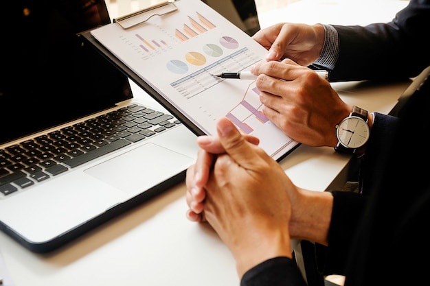 Femme d&#39;affaires travaillant dans son café et utilisant un ordinateur portable, en discutant les graphiques et les graphiques montrant les résultats de leur réussite.