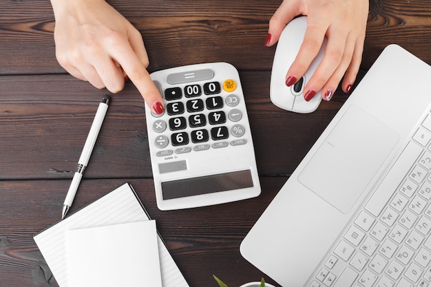 Photo femme d'affaires travaillant avec des données financières à la main à l'aide de la calculatrice