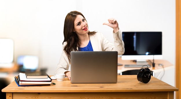 Femme d&#39;affaires travaillant avec son ordinateur portable et fier d&#39;elle-même au bureau