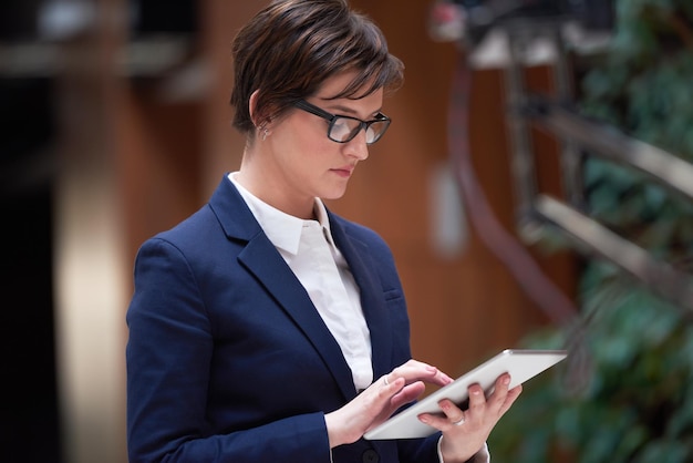 femme d'affaires travaillant sur une tablette à l'intérieur d'un bureau moderne