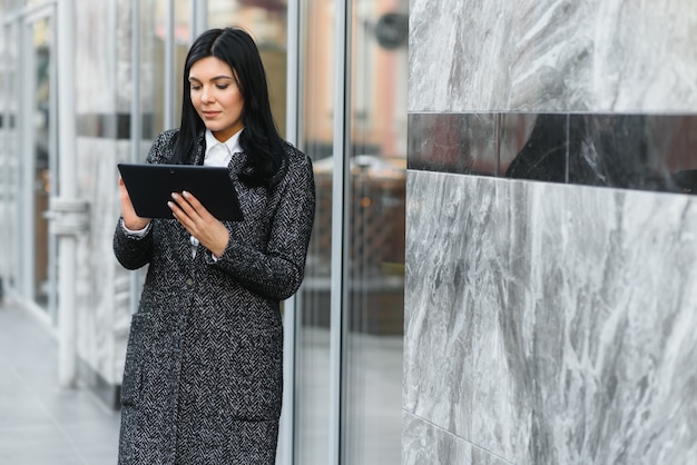 Femme d'affaires travaillant sur une tablette numérique à l'extérieur