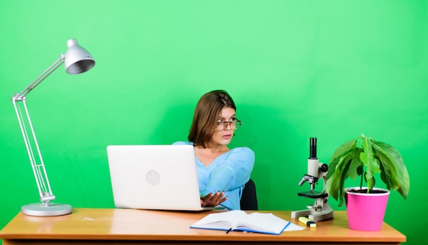 Femme d'affaires travaille au bureau sur ordinateur portable information de femme d'affaires de science numérique Femme d'affaires biologiste chimiste avec microscope sur table secrétaire concentrée sur le lieu de travail